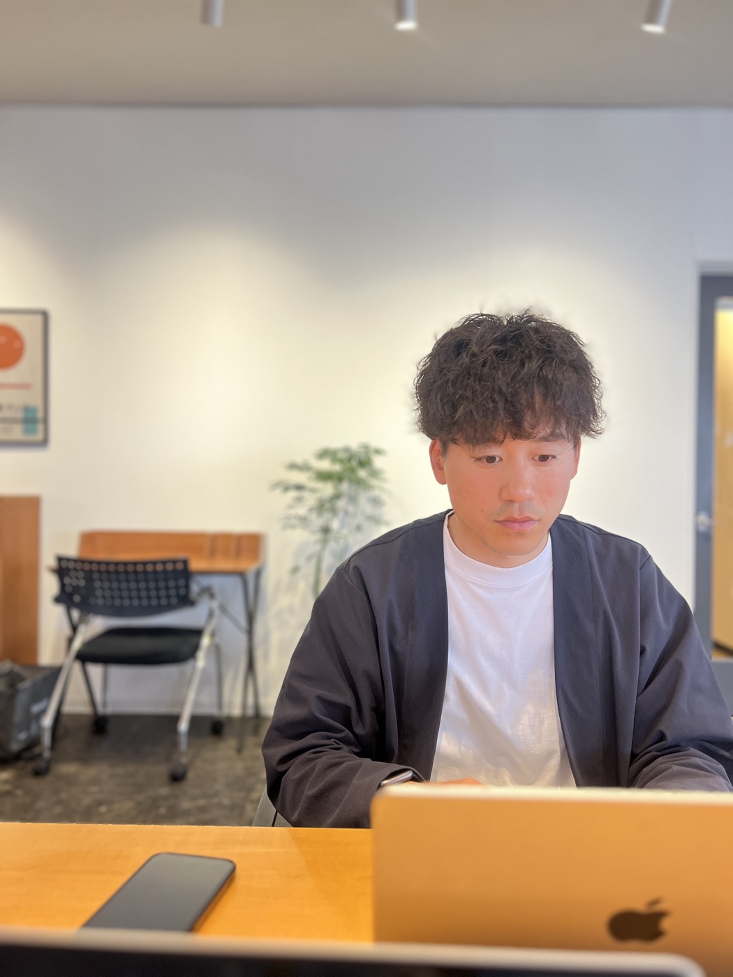 オフィスでノートパソコンに向かって作業する町田涼